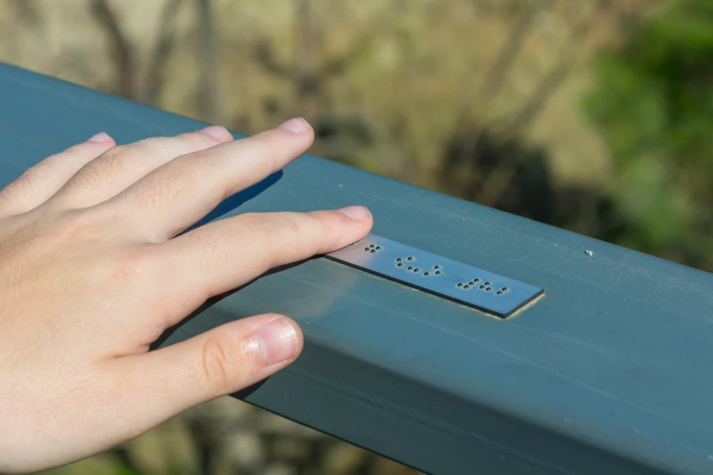 A hand touches the sleek modern signage